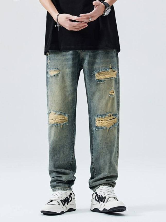 Men's distressed wide leg jeans in washed denim with ripped details and relaxed fit